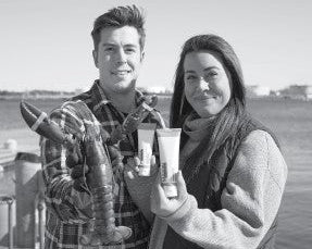 Two people by the water hold a live lobster and skincare tubes, showing a marine-derived lobster protein product.