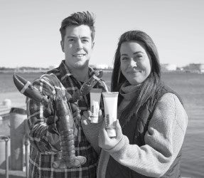 Two people by the water hold a live lobster and skincare tubes, showing a marine-derived lobster protein product.