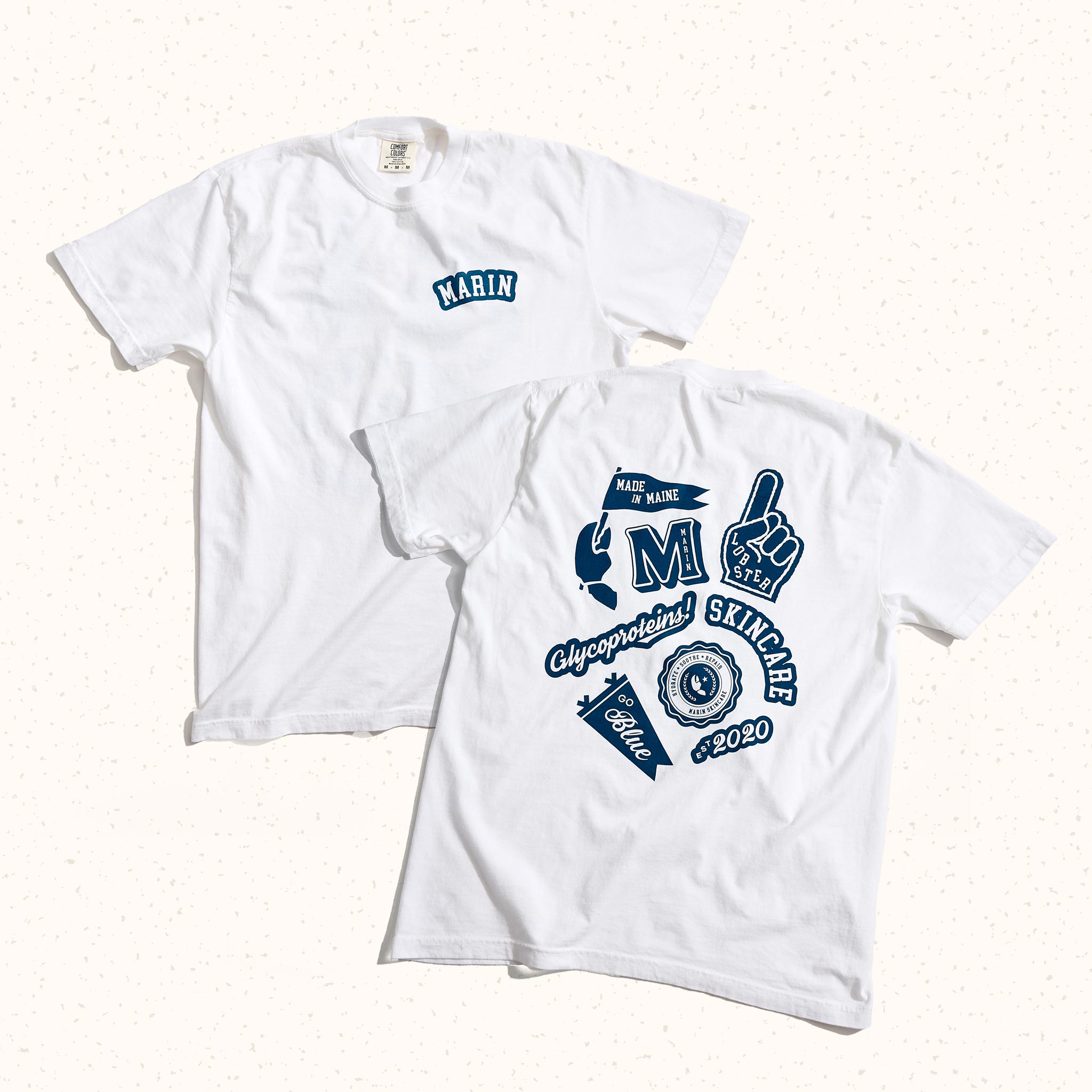 White tee with 'MARIN' chest and back graphic: MADE IN MAINE; M; LOBSTER; Glycoproteins!; SKINCARE; Blue; est 2020