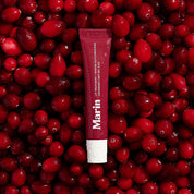 Marin lip treatment tube on bed of cranberries — LIP TREATMENT + MARINE GLYCOPROTEINS CRANBERRY NET WT .5 OZ