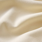 Cream-colored knit fabric with soft folds and fine ribbed texture