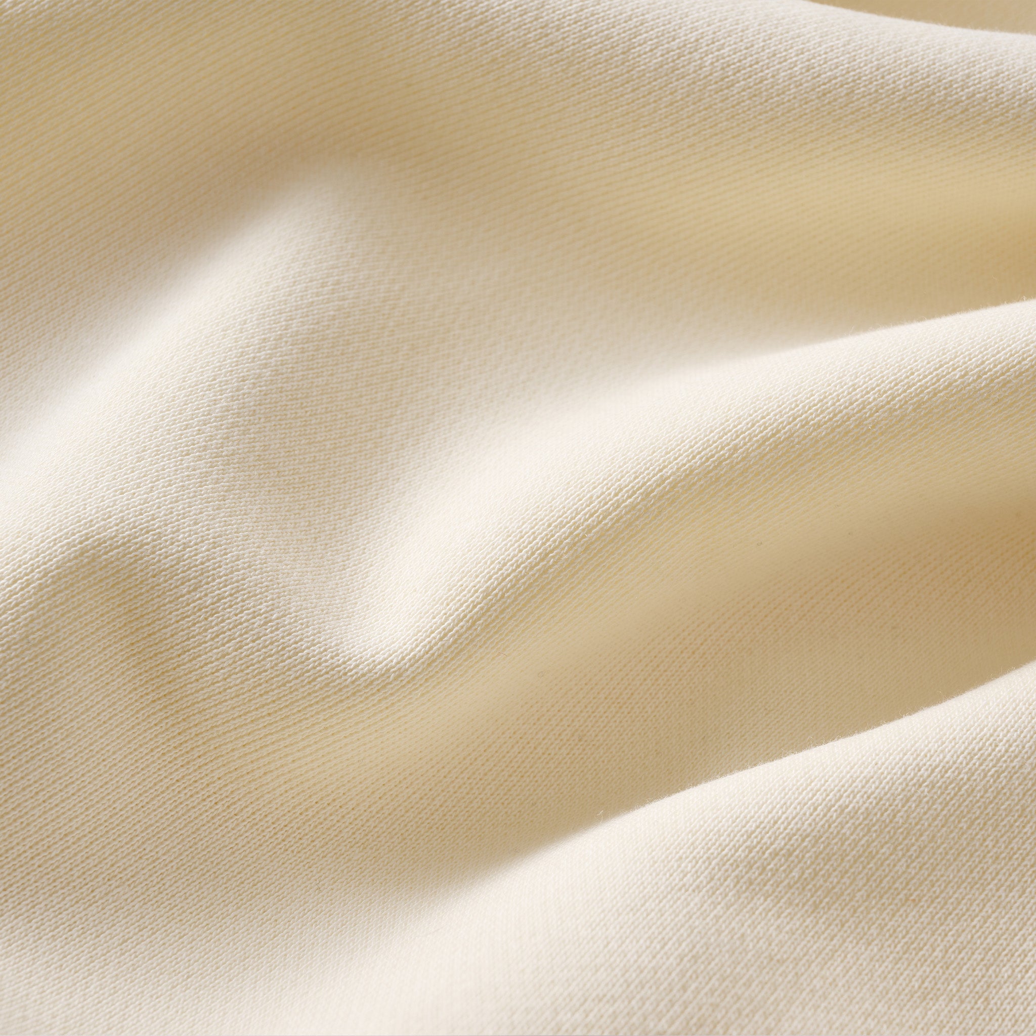 Cream-colored knit fabric with soft folds and fine ribbed texture