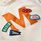 Cream sweatshirt close-up with orange felt "M" and patches reading MARIN, Go Blue, GLYCO PROTEINS.