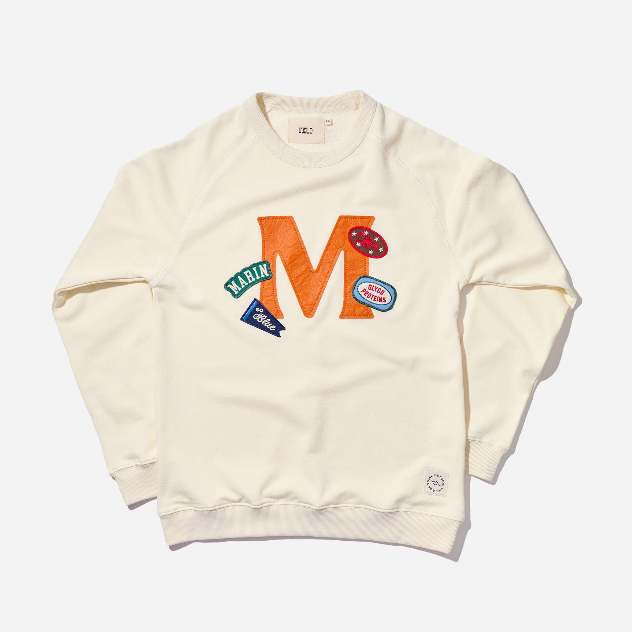Cream crewneck sweatshirt with large orange 'M' and stitched patches reading MARIN and Blue