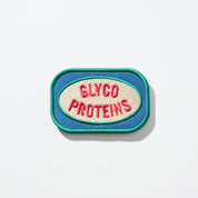 Rectangular blue-and-green embroidered patch with cream oval and red text 'GLYCO PROTEINS'.