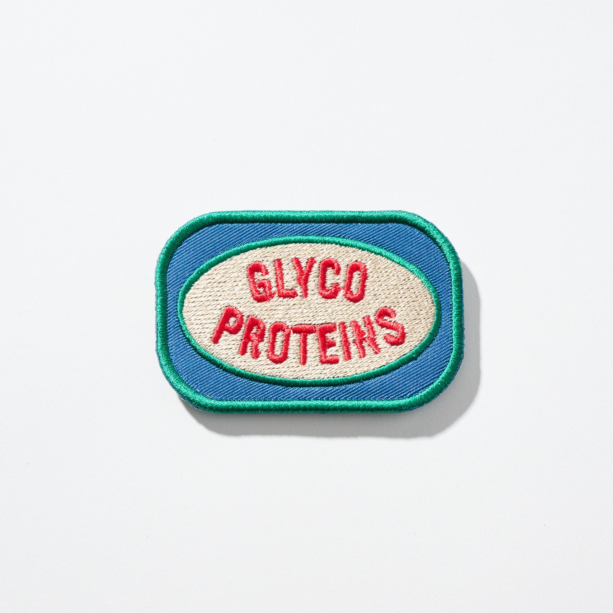 Rectangular blue-and-green embroidered patch with cream oval and red text 'GLYCO PROTEINS'.