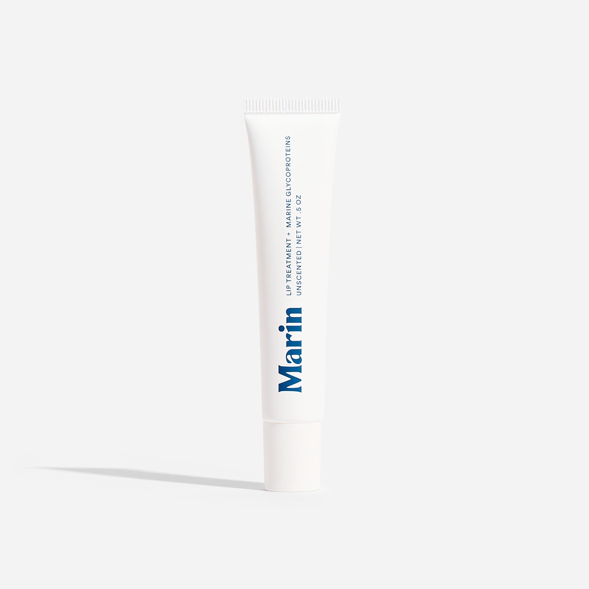 Marin lip treatment white tube labeled LIP TREATMENT + MARINE GLYCOPROTEINS UNSCENTED NET WT. 0.5 OZ
