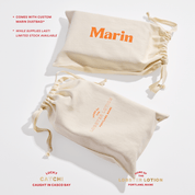 Cream canvas drawstring dust bags with orange Marin logo and small Lobster Lotion, Portland Maine text
